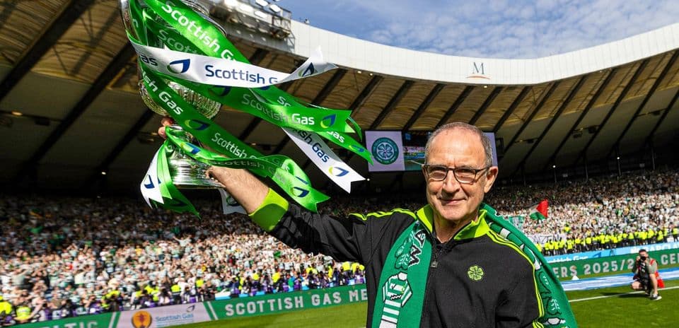 Человек с кубком Scottish Gas на стадионе