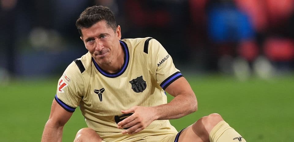 Игрок сидит на поле в желтой форме Барселоны