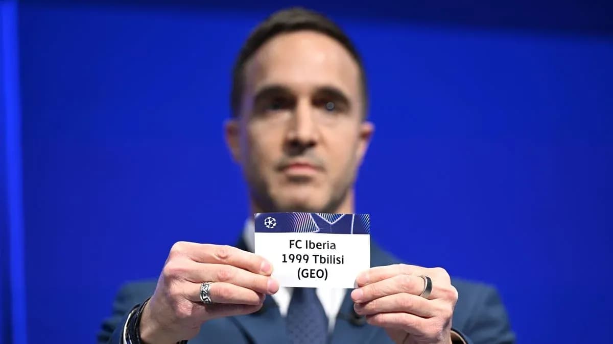 Человек держит карточку FC Iberia 1999 Тбилиси
