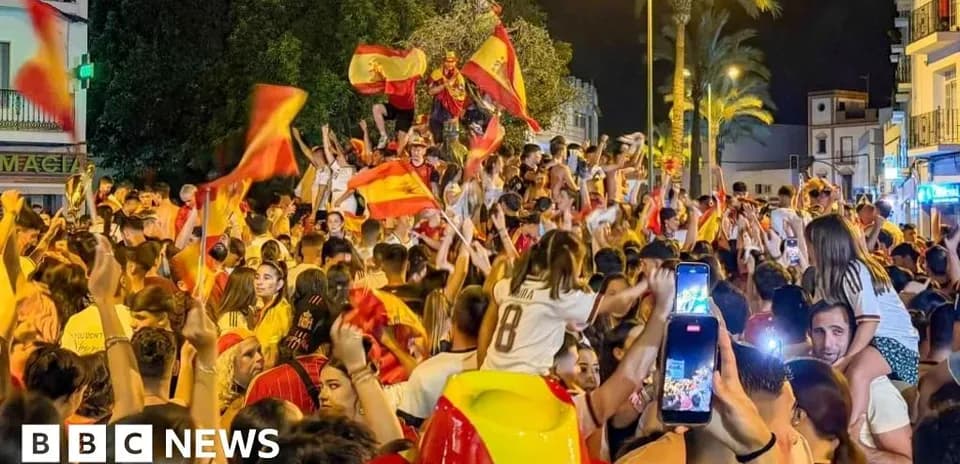 Люди празднуют с флагами Испании на улице