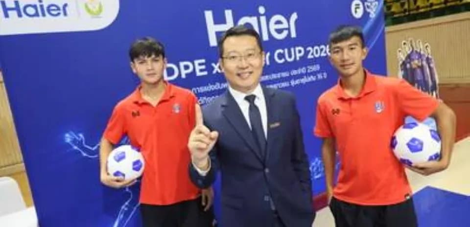 Два юных футболиста и представитель компании Haier