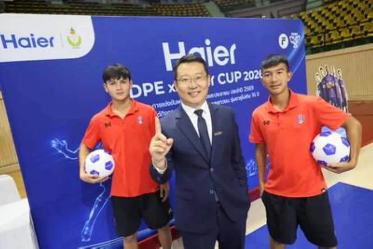 Два юных футболиста и представитель компании Haier