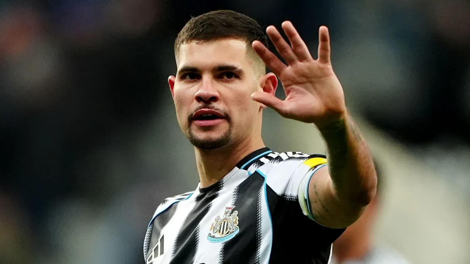 Игрок Newcastle United приветствует зрителей на стадионе