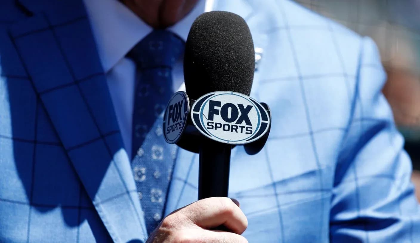 Микрофон FOX Sports в руках мужчины в костюме