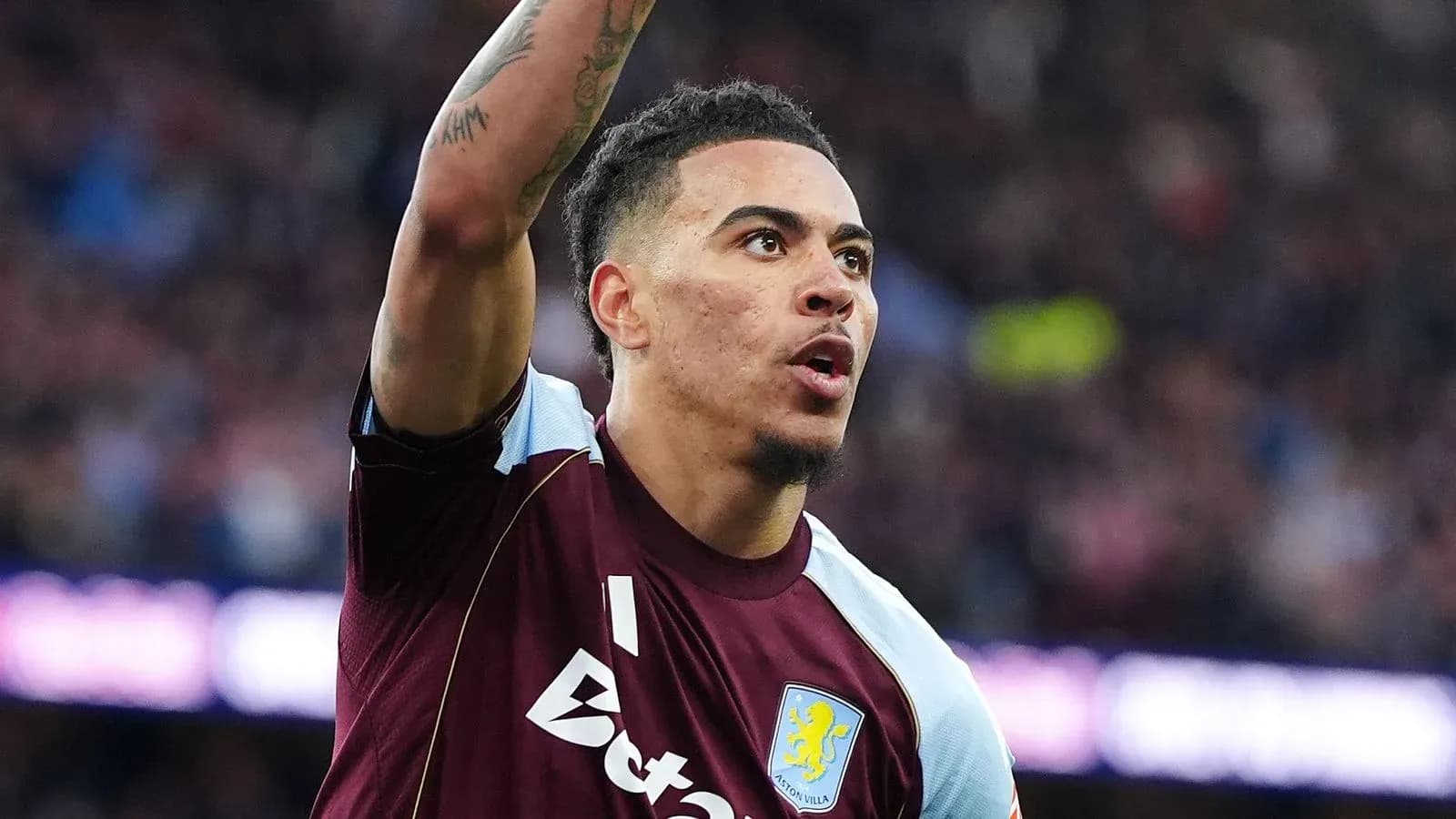 Игрок Aston Villa поднимает руку во время матча